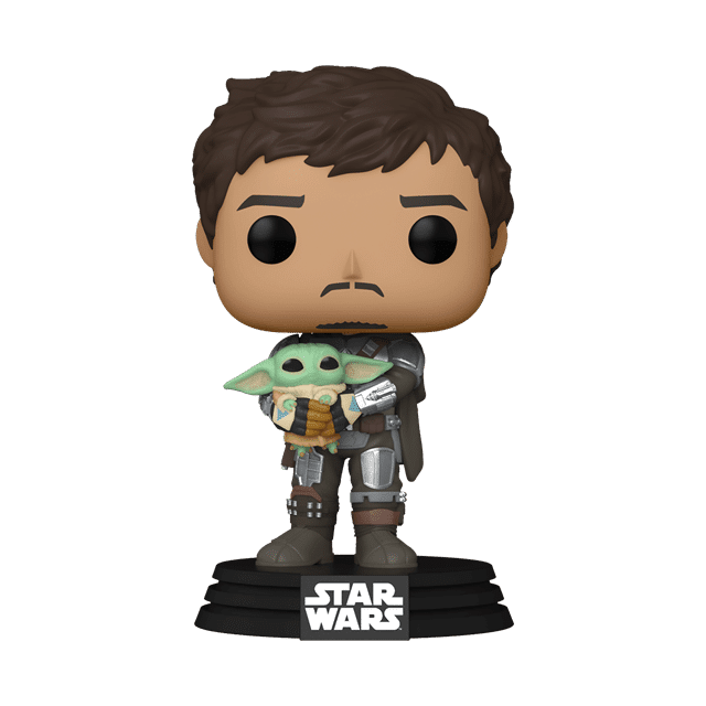 Pedro Pascal as Din Djarin holding the Child in The Mandalorian