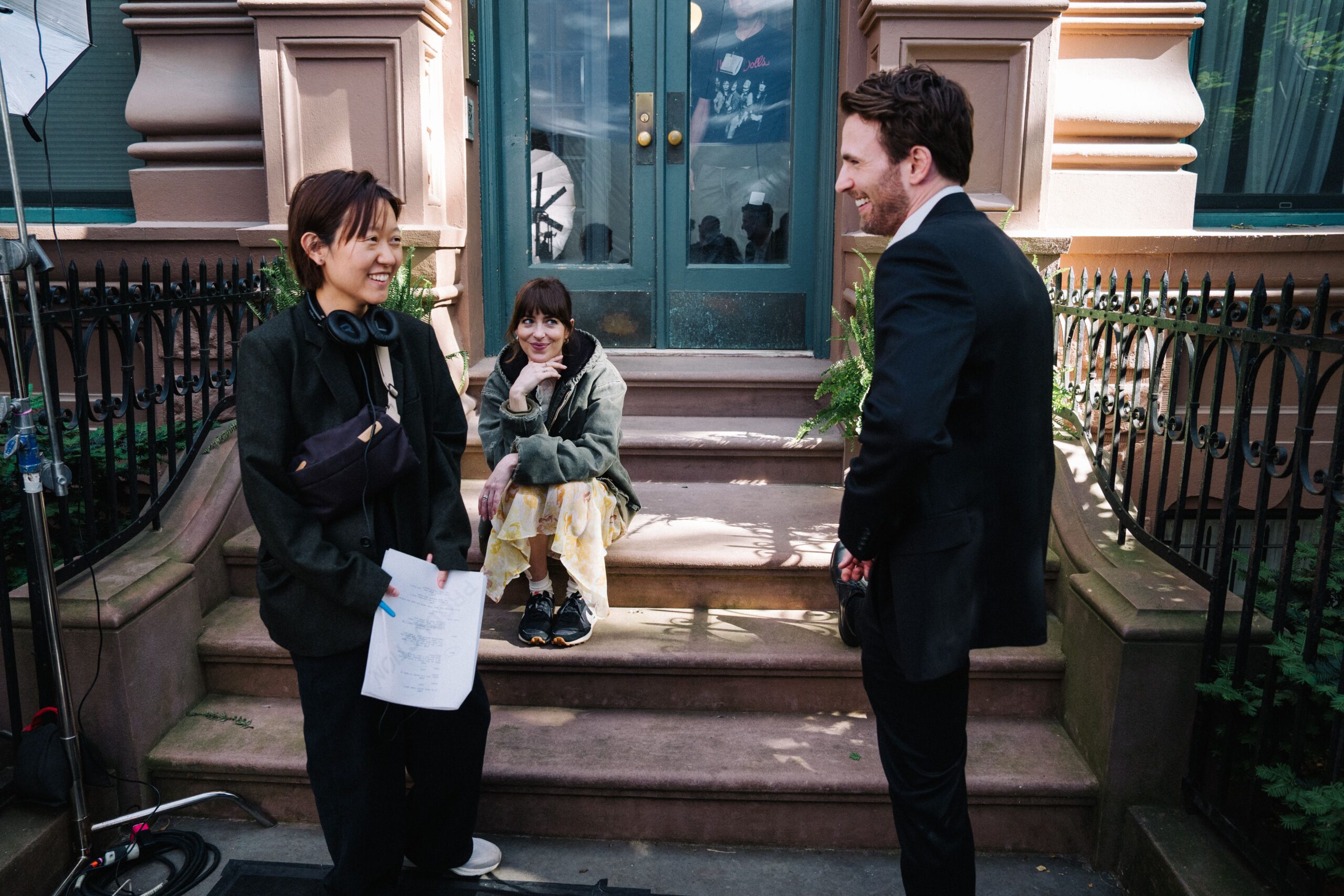 Celine Song, Dakota Johnson, and Chris Evans behind the scenes of Celine Song's romantic comedy film, Materialists